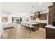 A spacious kitchen with a large island, modern appliances, and stylish pendant lighting overlooking a living room at 52 Reverie Heights Ave, Henderson, NV 89011