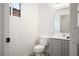 A clean bathroom has a grey vanity, white toilet, and natural light from a window at 5573 La Perla Ct, Las Vegas, NV 89122