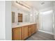 Bright bathroom boasts double sinks with wood cabinets, a large mirror, and a glass-enclosed shower at 5573 La Perla Ct, Las Vegas, NV 89122