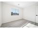 An airy bedroom has light wood-look floors and a window with horizontal blinds at 5573 La Perla Ct, Las Vegas, NV 89122