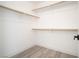 Walk-in closet features white walls, gray flooring, and wooden closet rods for optimal storage at 5573 La Perla Ct, Las Vegas, NV 89122