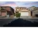 Inviting two-story home featuring a two-car garage, desert landscaping, and a cozy front entryway at 5573 La Perla Ct, Las Vegas, NV 89122