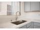 A stainless steel kitchen sink features quartz countertops and grey cabinetry at 5573 La Perla Ct, Las Vegas, NV 89122