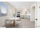 Modern, virtually staged kitchen with stainless steel appliances, light gray cabinets, and a cozy breakfast nook at 5573 La Perla Ct, Las Vegas, NV 89122
