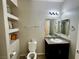 This bathroom features a toilet, sink with vanity, and built in storage shelving at 5941 Galway Bay St, North Las Vegas, NV 89081
