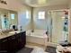 Bright bathroom featuring a soaking tub, glass enclosed shower and vanity at 5941 Galway Bay St, North Las Vegas, NV 89081