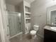Bright bathroom with glass-enclosed shower, built-in shelves, and granite-topped vanity at 5941 Galway Bay St, North Las Vegas, NV 89081