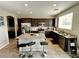 Modern kitchen with stainless steel appliances, granite countertops, dark wood cabinets, and island with bar stool seating at 5941 Galway Bay St, North Las Vegas, NV 89081