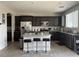 Modern kitchen with dark wood cabinets, island with seating, and stainless steel appliances at 5941 Galway Bay St, North Las Vegas, NV 89081