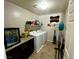 The laundry room is equipped with a washer, dryer, mini-fridge, and storage at 5941 Galway Bay St, North Las Vegas, NV 89081