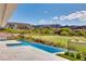 Infinity pool overlooking a lush golf course and mountain views on a sunny day at 641 Majestic Rim Dr, Henderson, NV 89012