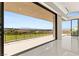 A luxurious covered balcony showcasing panoramic city and mountain views through expansive sliding glass doors at 641 Majestic Rim Dr, Henderson, NV 89012