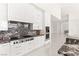 Modern kitchen with marble countertops, stainless appliances, a gas cooktop, and an adjoining living area at 641 Majestic Rim Dr, Henderson, NV 89012