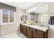 Elegant bathroom featuring double sinks, granite countertops, and plenty of natural light at 711 Florence Isle Ave, Henderson, NV 89015