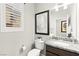 Stylish powder room with a granite countertop, decorative art, and ample natural light from the window at 711 Florence Isle Ave, Henderson, NV 89015