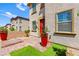 Inviting front entry with a red door, landscaped planters, and a well-maintained brick pathway at 711 Florence Isle Ave, Henderson, NV 89015