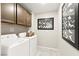 Functional laundry room with washer, dryer, and overhead cabinets, offering convenience and organization at 711 Florence Isle Ave, Henderson, NV 89015