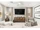 Cozy living room with neutral tones, stylish furniture, decorative pillows, and large television at 711 Florence Isle Ave, Henderson, NV 89015