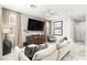 Modern living room with a large screen TV, neutral decor, and plenty of natural light at 711 Florence Isle Ave, Henderson, NV 89015