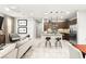 Open concept living room with kitchen featuring stainless steel appliances, granite counters and dark wood cabinets at 711 Florence Isle Ave, Henderson, NV 89015