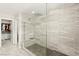 Large walk-in shower with gray tile, a built-in bench, and a glass surround at 711 Florence Isle Ave, Henderson, NV 89015