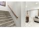 Carpeted staircase with a wooden handrail, leading to the upper level of the home, open to living area at 711 Florence Isle Ave, Henderson, NV 89015
