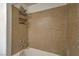 Bathroom featuring a tub and shower with a light brown wall surround and metal storage caddy at 8000 Badura Ave # 1168, Las Vegas, NV 89113