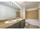 Bathroom featuring double sinks, a large mirror with lighting, and a combined tub and shower with tan wall surround at 8000 Badura Ave # 1168, Las Vegas, NV 89113