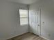 Bright bedroom featuring wood-look floors, a window with blinds, and a white door at 8000 Badura Ave # 1168, Las Vegas, NV 89113
