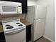White electric stove and microwave, dark cabinets at 8000 Badura Ave # 1168, Las Vegas, NV 89113