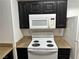 Kitchen featuring white appliances with dark paneled cabinets at 8000 Badura Ave # 1168, Las Vegas, NV 89113