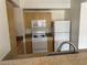 Well-lit kitchen featuring wooden cabinets, white appliances, and granite countertops at 8000 Badura Ave # 1168, Las Vegas, NV 89113