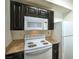 Cozy kitchen features white appliances, dark cabinetry, and light countertops at 8000 Badura Ave # 1168, Las Vegas, NV 89113
