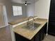 Close-up of kitchen sink with granite counter looking into living room at 8000 Badura Ave # 1168, Las Vegas, NV 89113