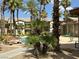 Community pool featuring palm trees, lounge chairs, and a nearby building with apartments at 8000 Badura Ave # 1168, Las Vegas, NV 89113