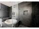 Luxurious bathroom showcasing a soaking tub, elegant tile work, and a glass-enclosed shower at 8244 Cupertino Heights Way, Las Vegas, NV 89178