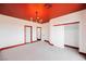 Bright bedroom with a red ceiling, chandelier, and two closets at 8244 Cupertino Heights Way, Las Vegas, NV 89178