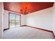 Bright bedroom with a red ceiling, chandelier, and a sliding glass door at 8244 Cupertino Heights Way, Las Vegas, NV 89178