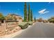 A decorative neighborhood entrance sign with lush trees and landscaping at 8244 Cupertino Heights Way, Las Vegas, NV 89178