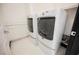 Bright laundry room with full-size, white, front-load washer and dryer, plus ample shelving at 8244 Cupertino Heights Way, Las Vegas, NV 89178