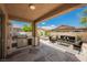 Inviting covered patio with built-in grill, outdoor seating area, and view of a spa at 8244 Cupertino Heights Way, Las Vegas, NV 89178