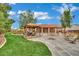 Expansive backyard with dining area, fire pit, artificial grass, and mature trees at 9180 Mohawk St, Las Vegas, NV 89139