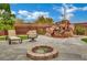 Inviting backyard featuring a rock waterfall, fire pit, and outdoor seating area perfect for entertaining at 9180 Mohawk St, Las Vegas, NV 89139