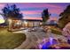Beautiful backyard with a stone patio, fire pit, and covered seating area offers a serene outdoor retreat at 9180 Mohawk St, Las Vegas, NV 89139