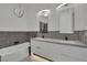 Modern bathroom features double sinks, a bathtub, and chic gray and white tiling at 9180 Mohawk St, Las Vegas, NV 89139