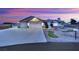 Charming home exterior with a two-car garage, landscaped yard, and beautiful sunset skies at 9180 Mohawk St, Las Vegas, NV 89139