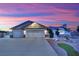 Gorgeous home exterior featuring a three-car garage and manicured landscaping at sunset at 9180 Mohawk St, Las Vegas, NV 89139