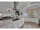 Open-concept kitchen with stainless steel appliances, white cabinets, and a modern island with an oven at 9180 Mohawk St, Las Vegas, NV 89139