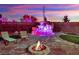 Relaxing backyard seating area with a fire pit and stone waterfall makes an inviting space for outdoor living and entertaining at 9180 Mohawk St, Las Vegas, NV 89139