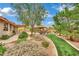 Lush, landscaped yard with a dining area and artificial turf creates a serene outdoor retreat at 9180 Mohawk St, Las Vegas, NV 89139